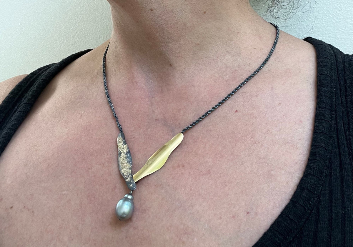 Suzanne Schwartz Collector's Favorites — 22k gold organic leaf pendant with Tahitian baroque pearl drop on dark cord necklace, worn