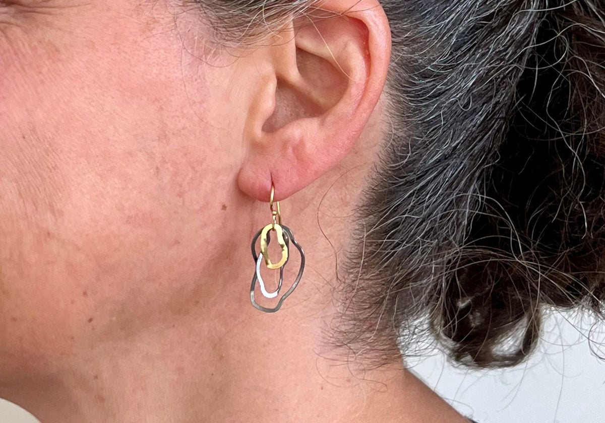 Suzanne Schwartz Ripple Collection — handmade oxidized Argentium silver organic loop drop earring, worn close-up