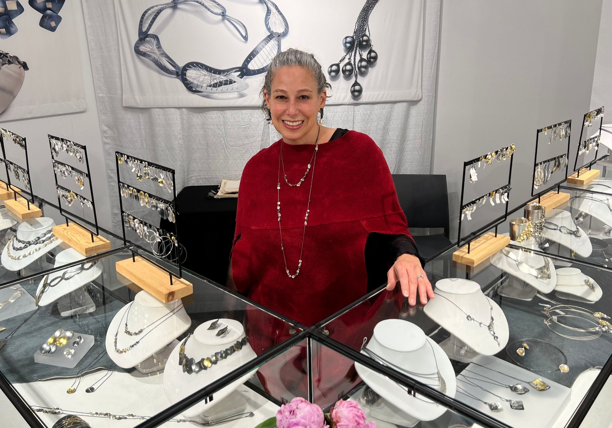 Suzanne Schwartz jewelry artist at craft show booth with handmade silver jewelry display