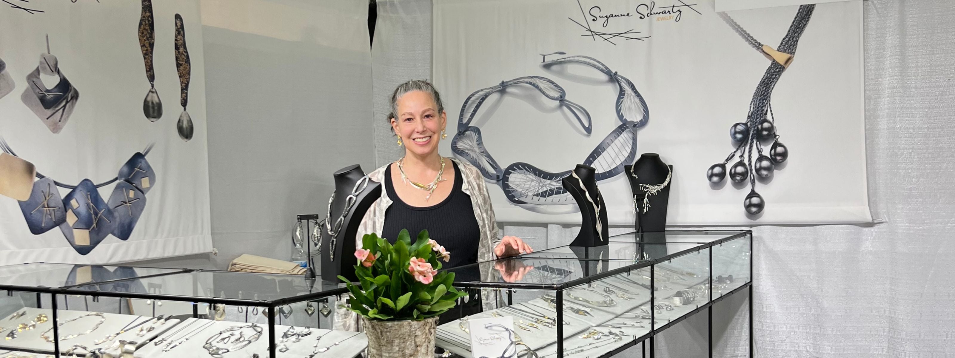 Suzanne Schwartz at craft show booth showcasing handmade Argentium silver and baroque pearl jewelry collection