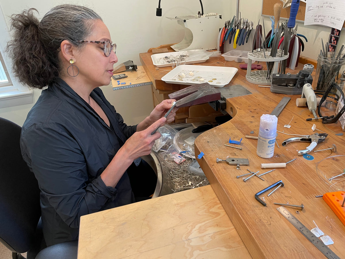 Suzanne Schwartz stitching silver at her jewelry bench in her New York studio
