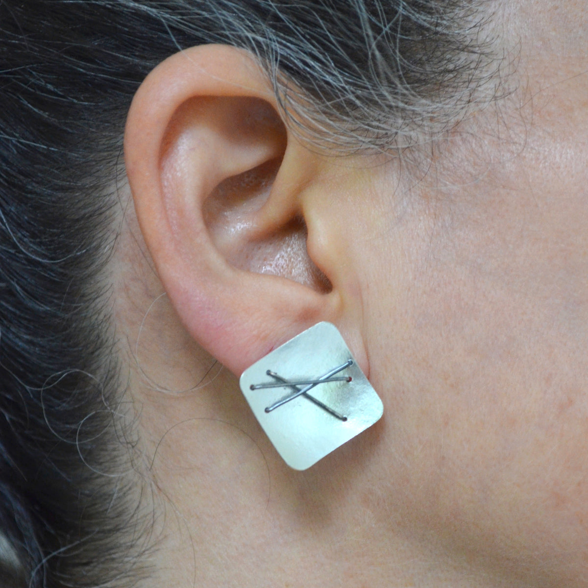 Suzanne Schwartz Wearing Three Stitch Stud Earrings