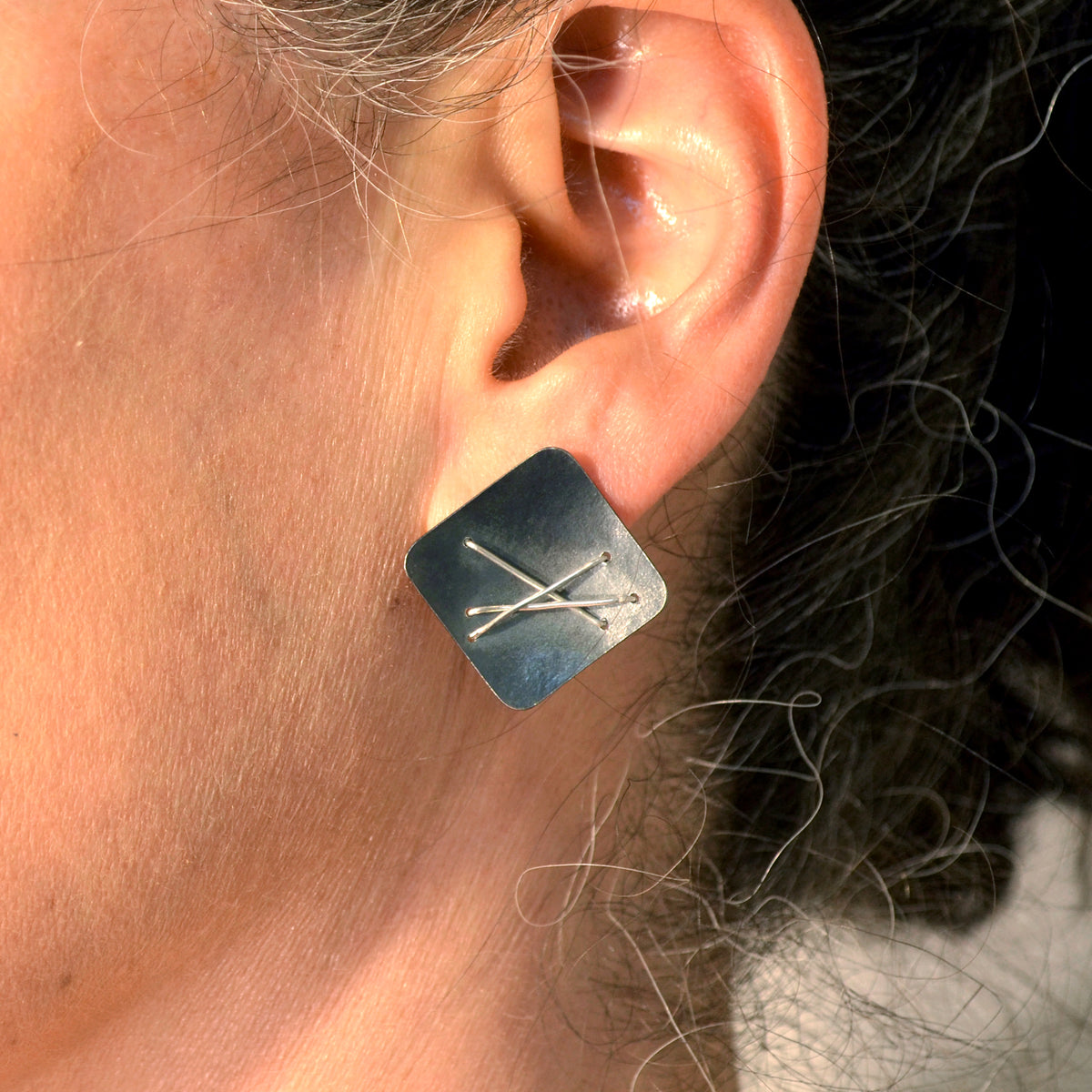 Suzanne Schwartz Wearing Three Stitch Stud Earrings