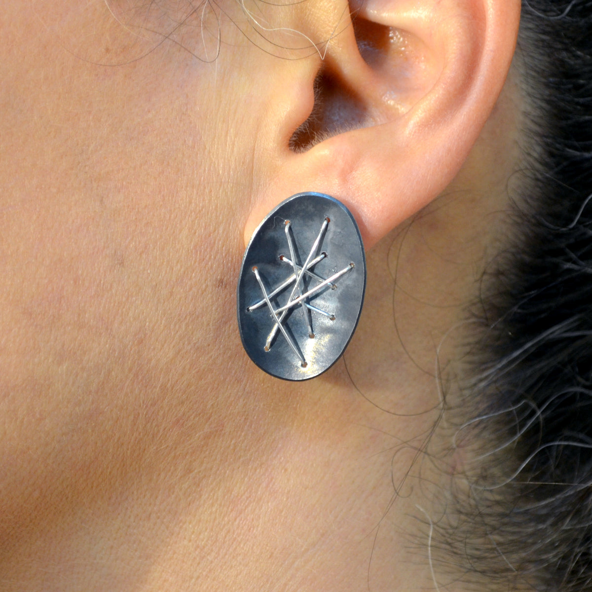 Suzanne Schwartz wearing Freeform Oval Stitched Silver Earrings